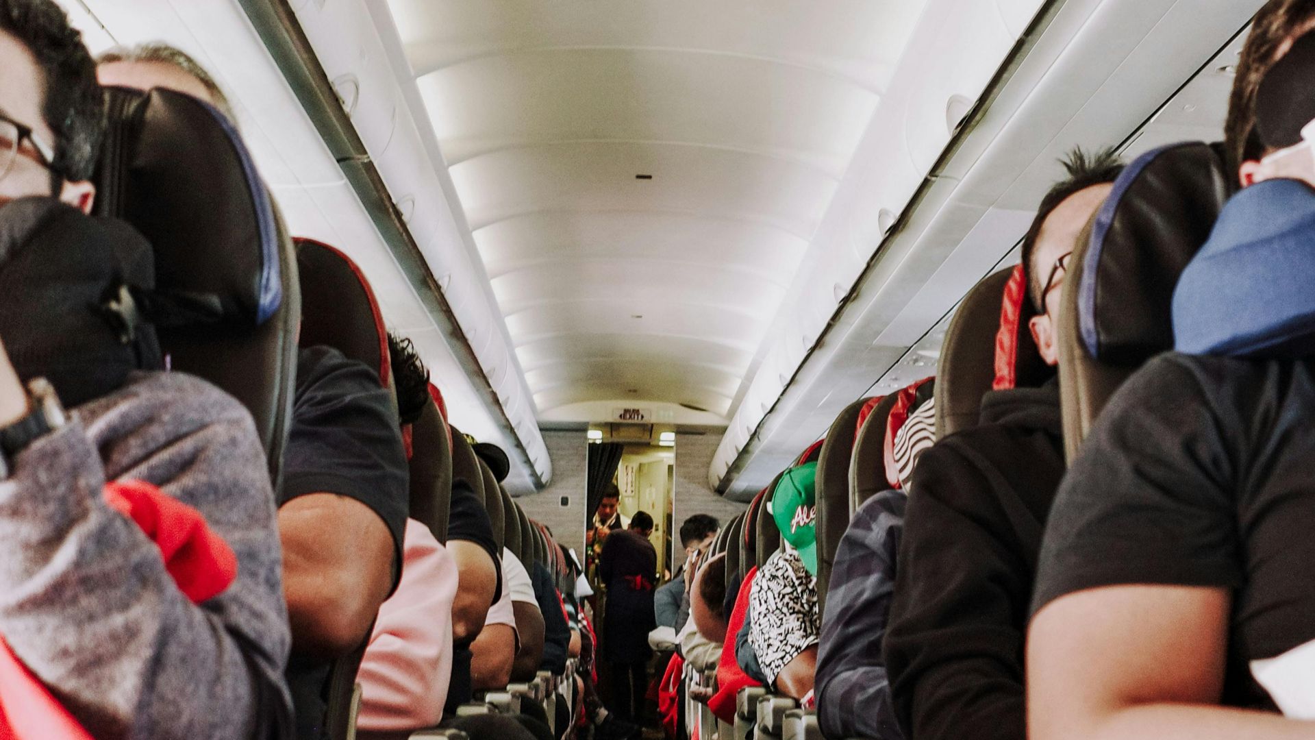Passengers seated inside a commercial airplane enjoying a comfortable flight.