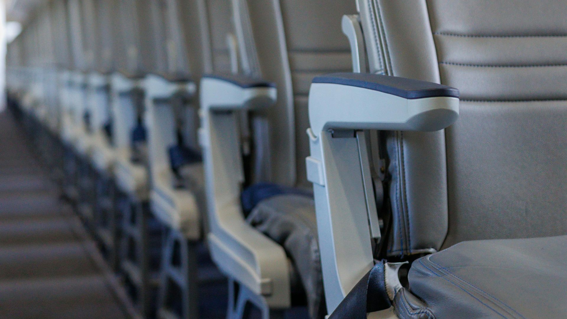 Interior view of an airplane cabin showcasing rows of empty seats, emphasizing travel and aviation themes.