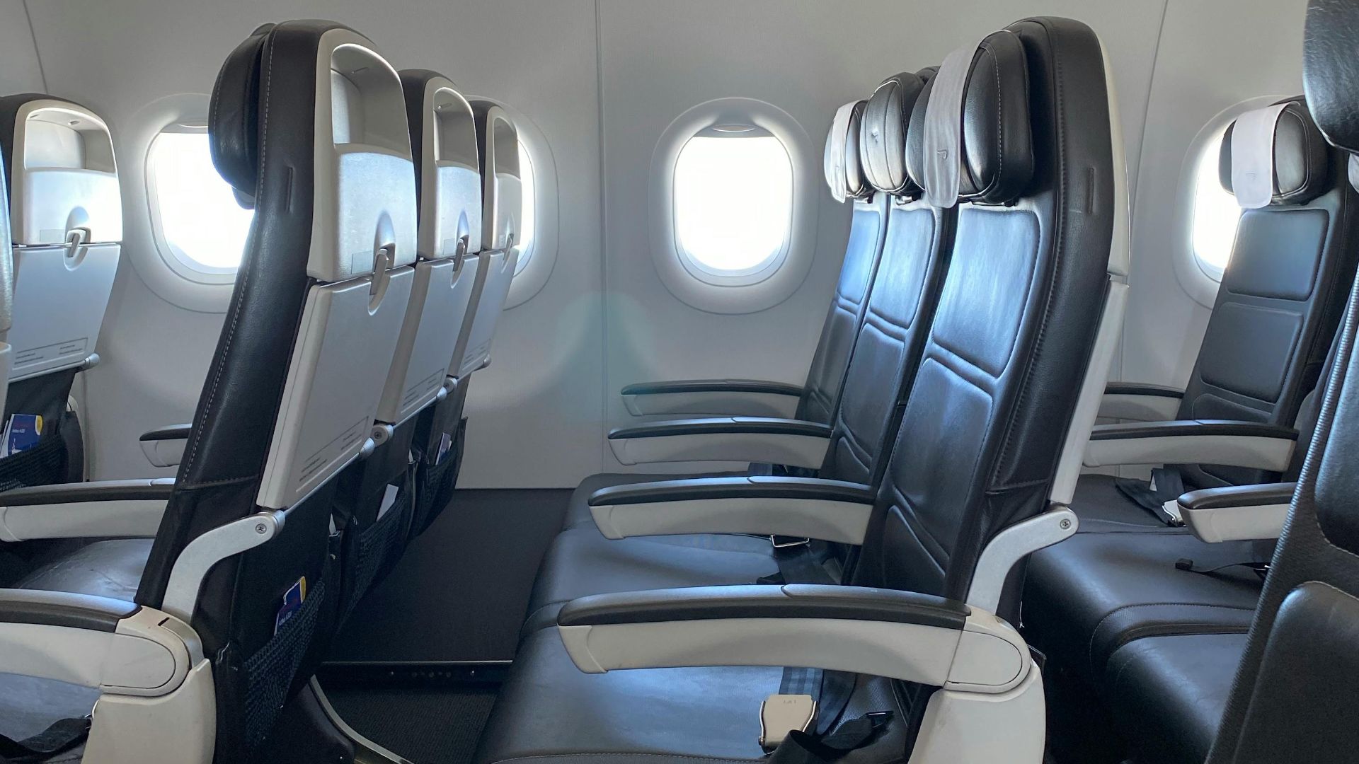 Spacious airline cabin showcasing empty rows of modern seating in an aircraft.