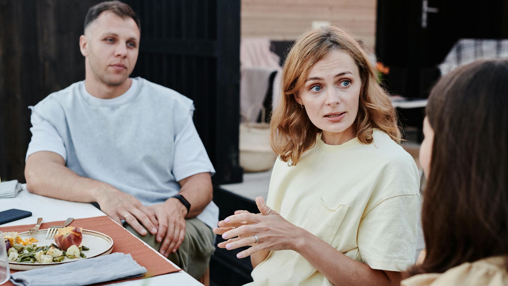 A group of adults enjoying a relaxed outdoor meal together.