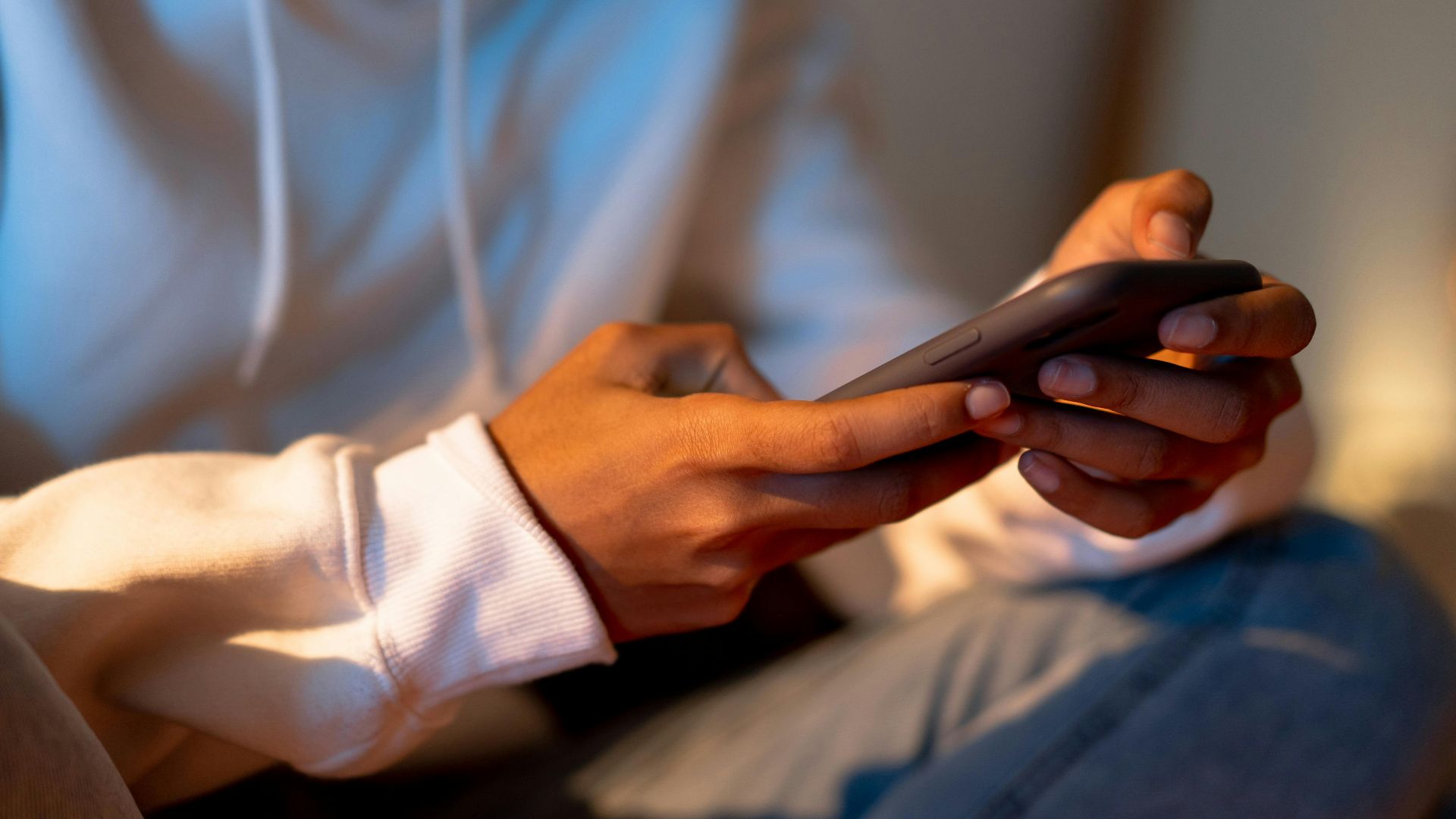 Close-up of a person holding a smartphone indoors, emphasizing digital interaction.