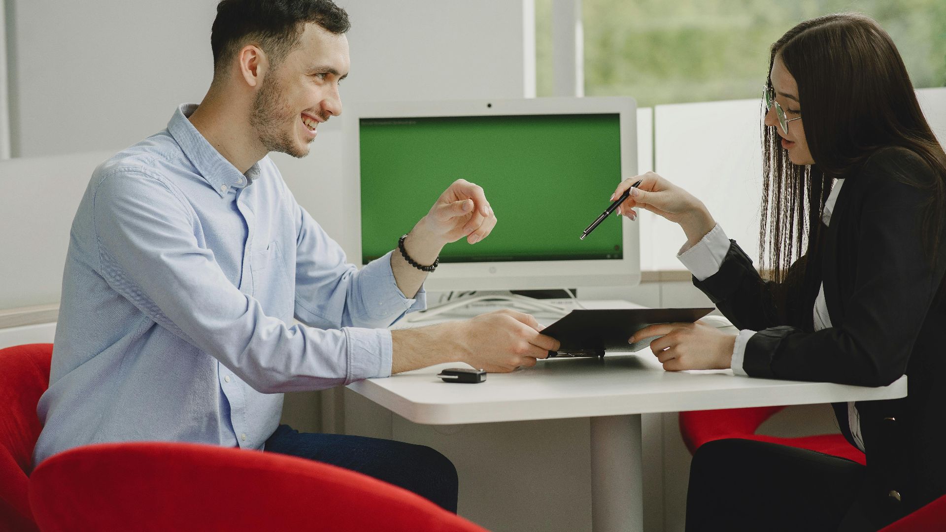 Two professionals engaged in a business discussion at a modern office desk.