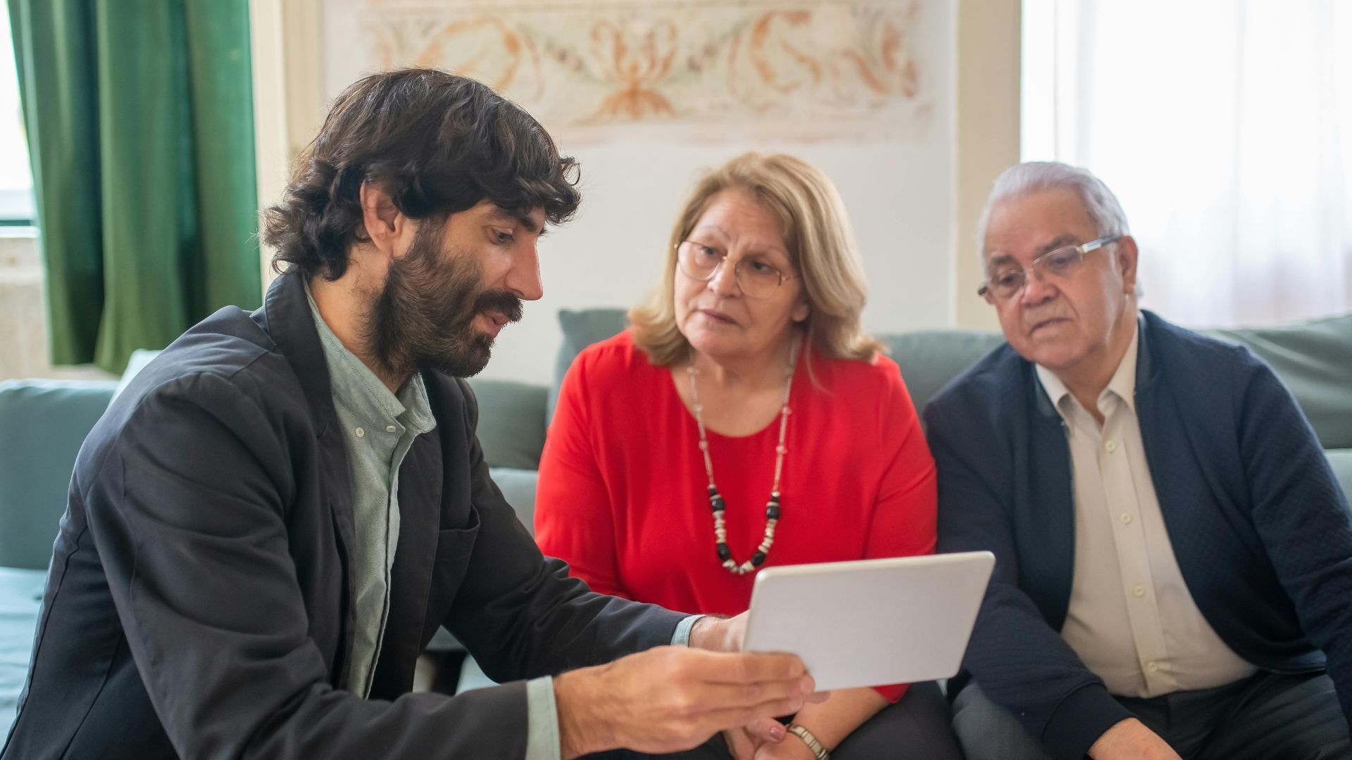 A financial advisor discussing investment options with an elderly couple in a cozy living room.