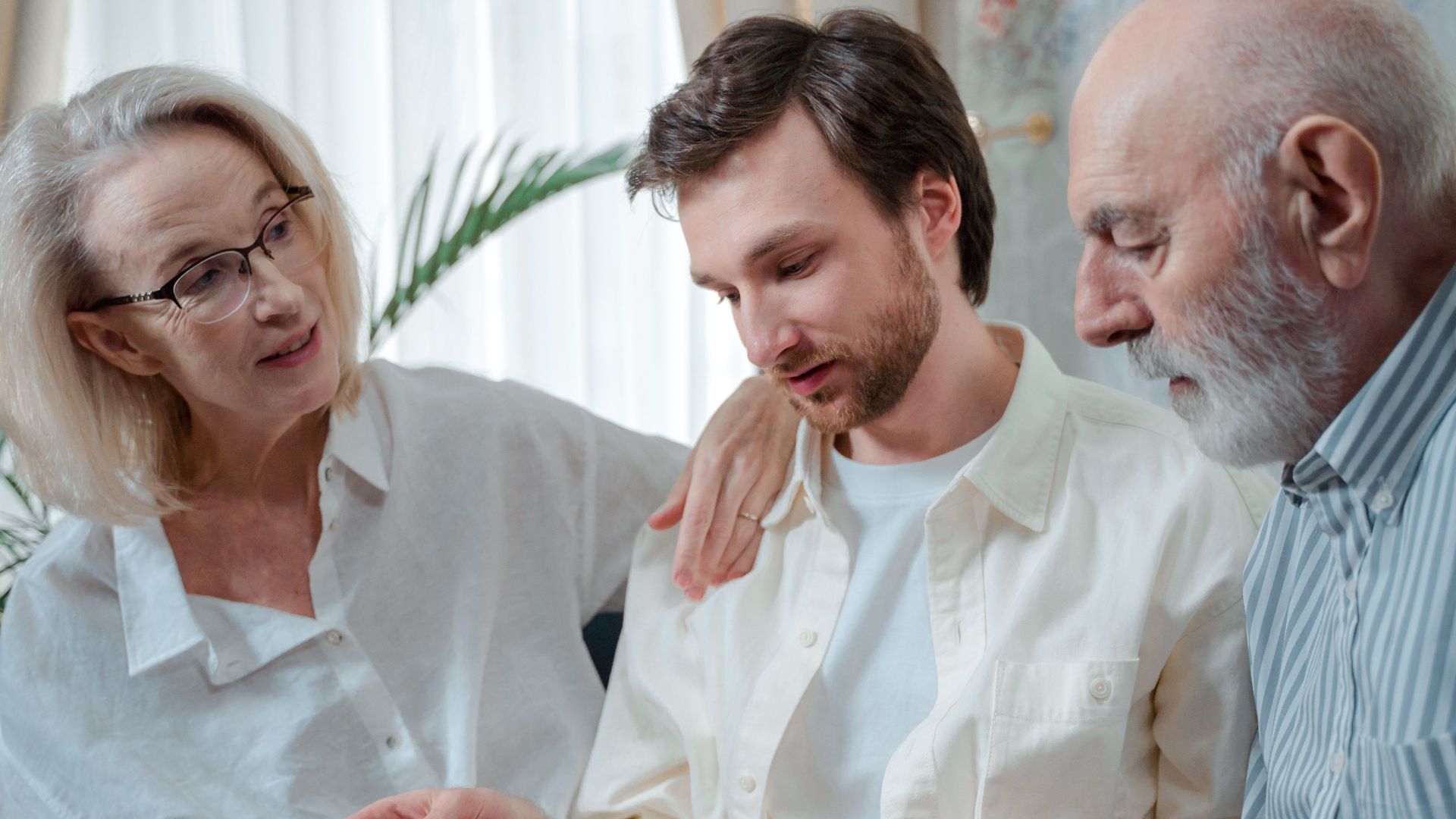 A family looks through a photo album, cherishing memories together indoors.