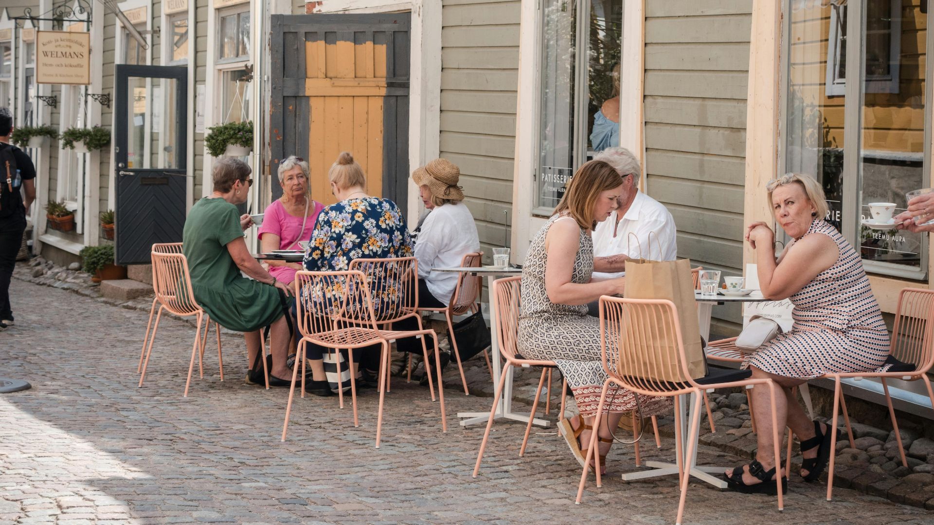 People enjoying a meal outdoors at a charming café in Porvoo, Finland.