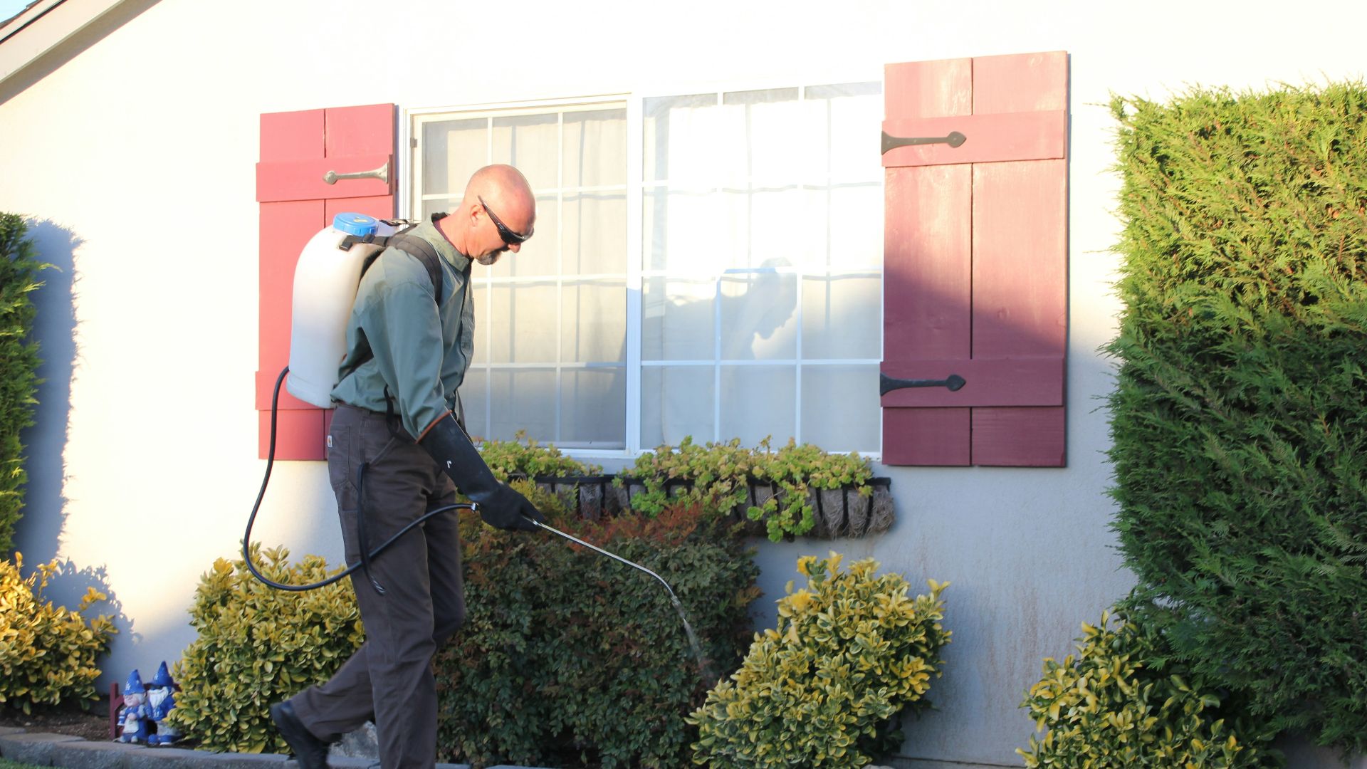 a man with a vacuum in front of a house