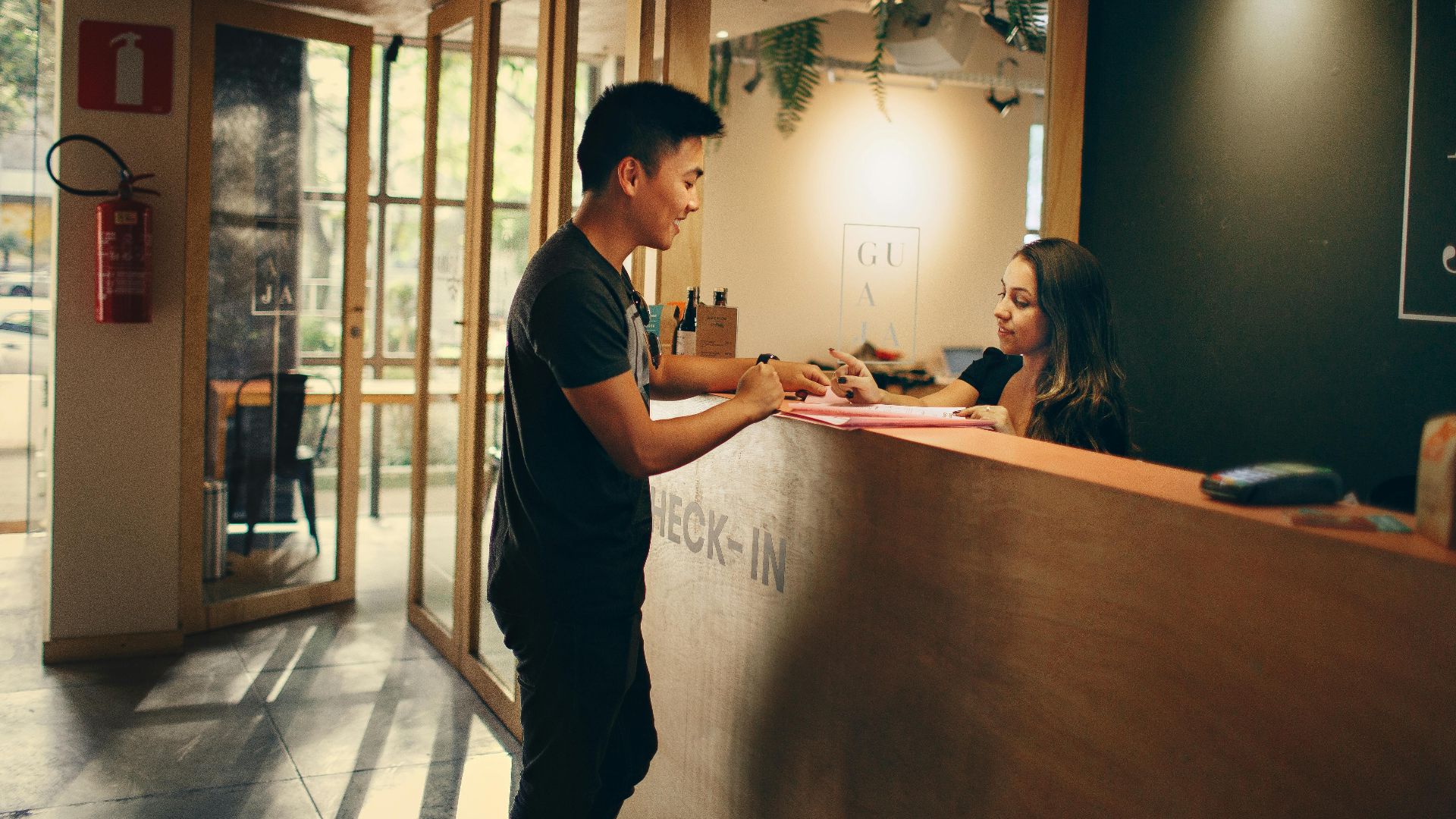A customer checks in at a hotel reception desk in Belo Horizonte, Brazil.