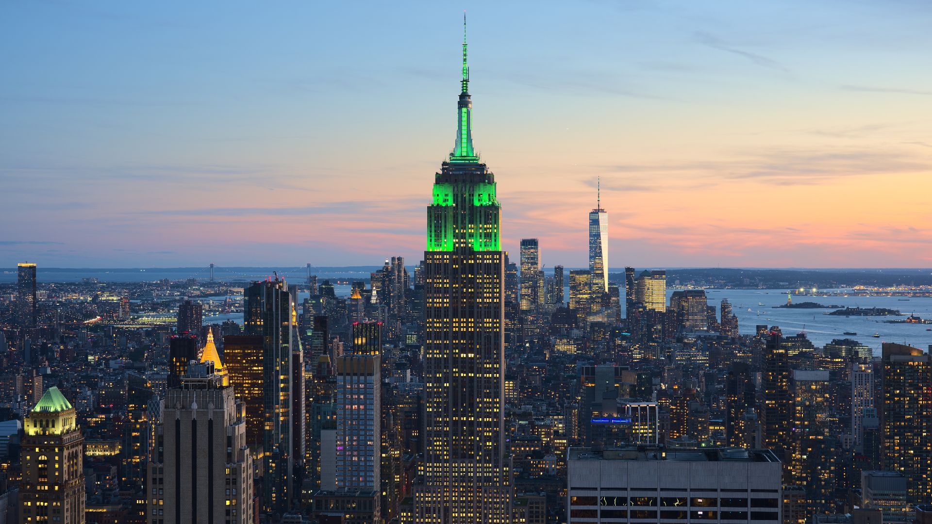View of the Empire State Building in New York City from the Top of the Rock at 30 Rockefeller Plaza during sunset. The tower was illuminated in green in honor of Climate Week NYC.[1]