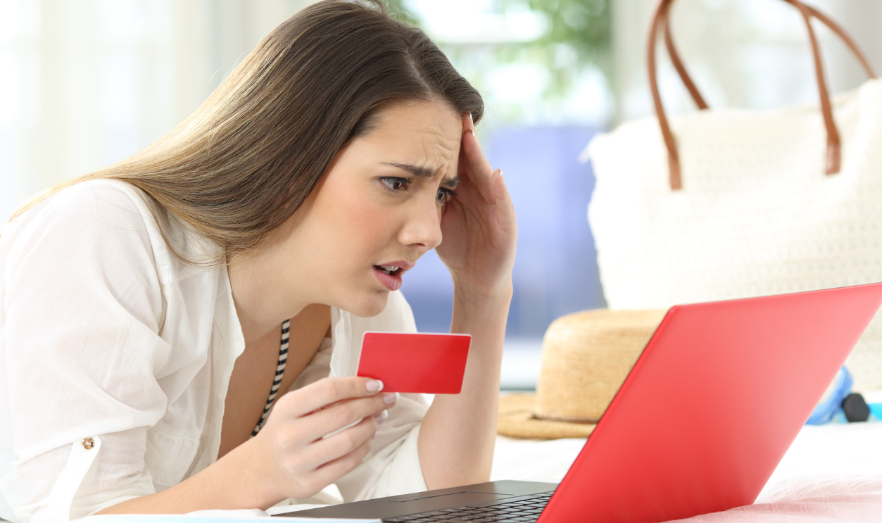 Worried guest having problems buying on line with credit card and a laptop in an hotel room during a travel on summer vacations