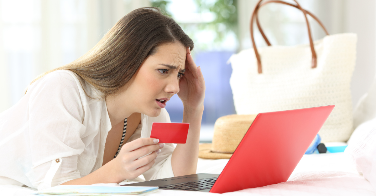 Worried guest having problems buying on line with credit card and a laptop in an hotel room during a travel on summer vacations