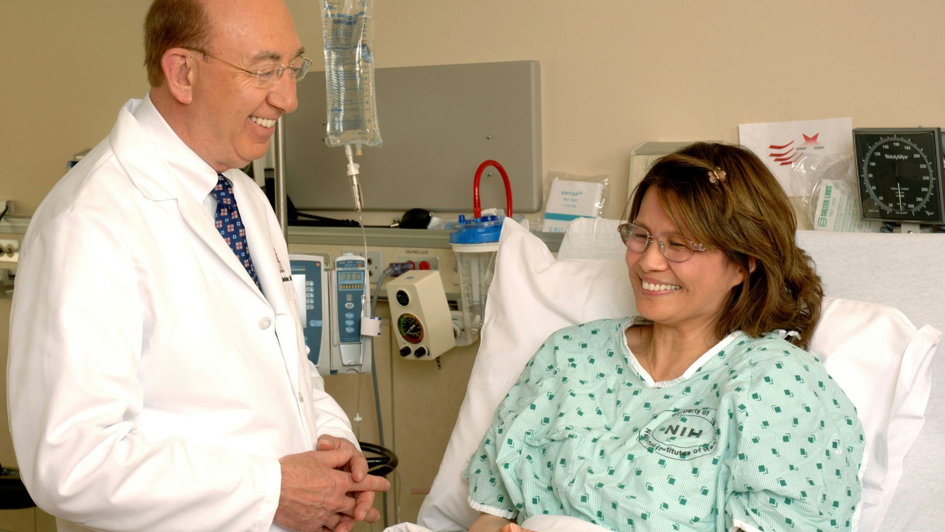 woman in teal scrub suit sitting beside man in white medical scrub suit