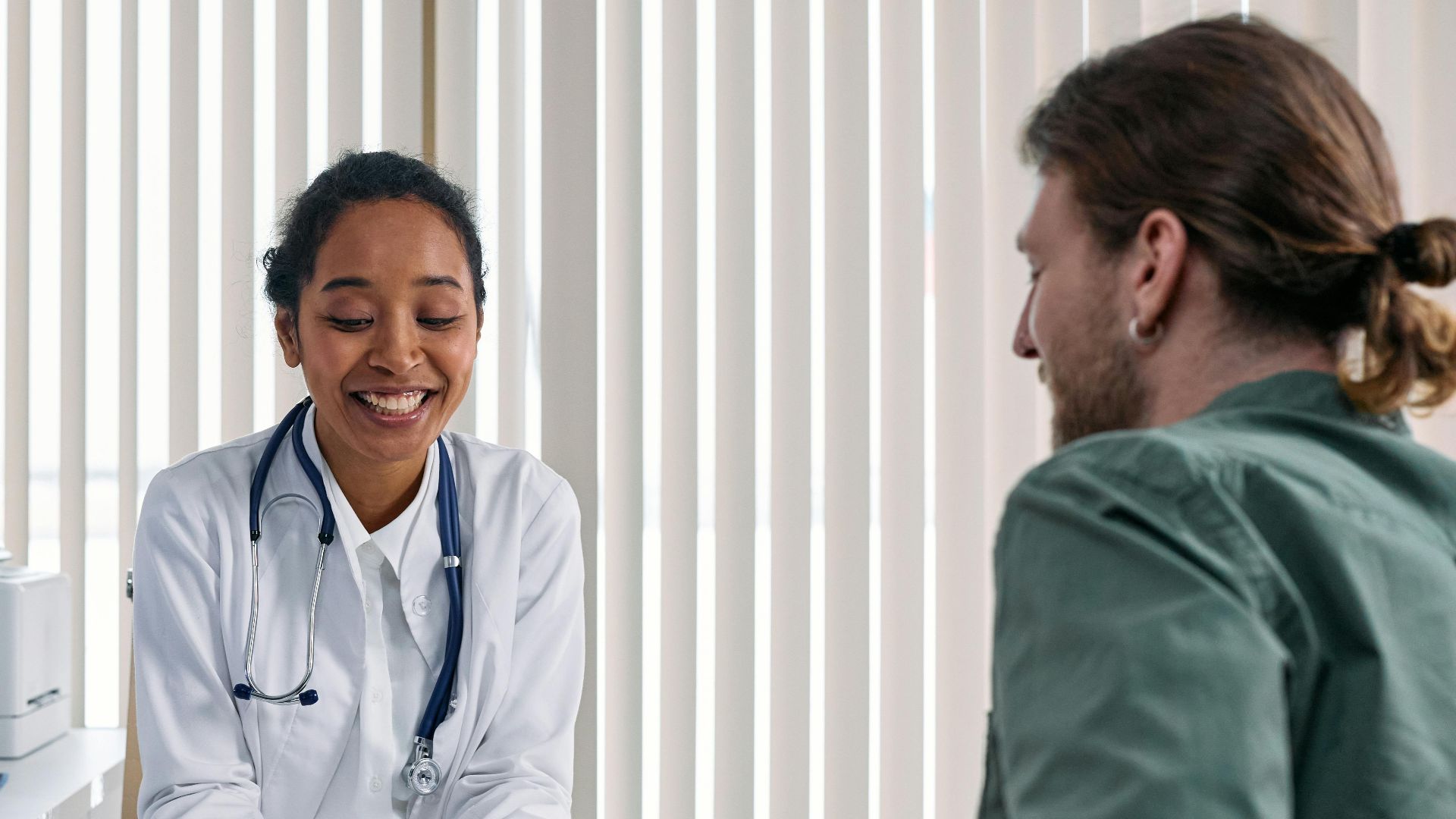 A doctor and patient engaging in a positive consultation in a bright clinic setting.