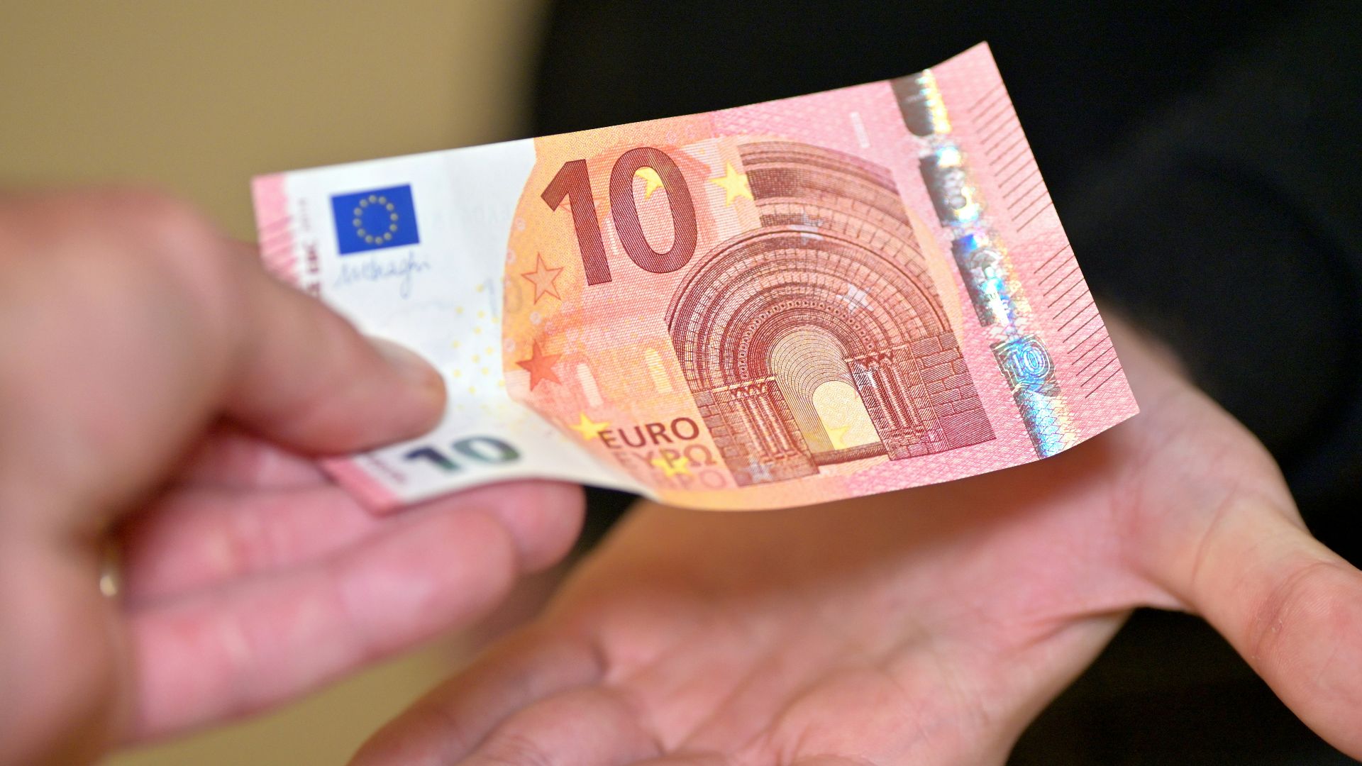 a person holding a ten euros bill in their hands