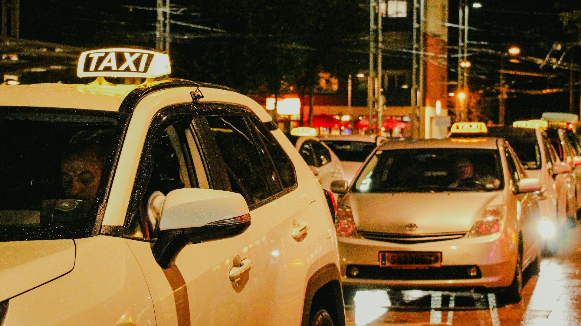 Taxis lined up under streetlights in Salzburg, Austria, captured at night.