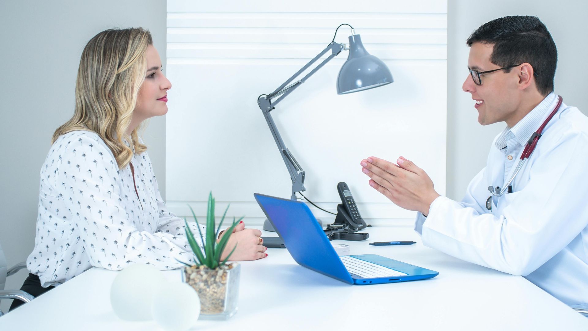 A doctor conducts a patient consultation in a bright, modern medical office.