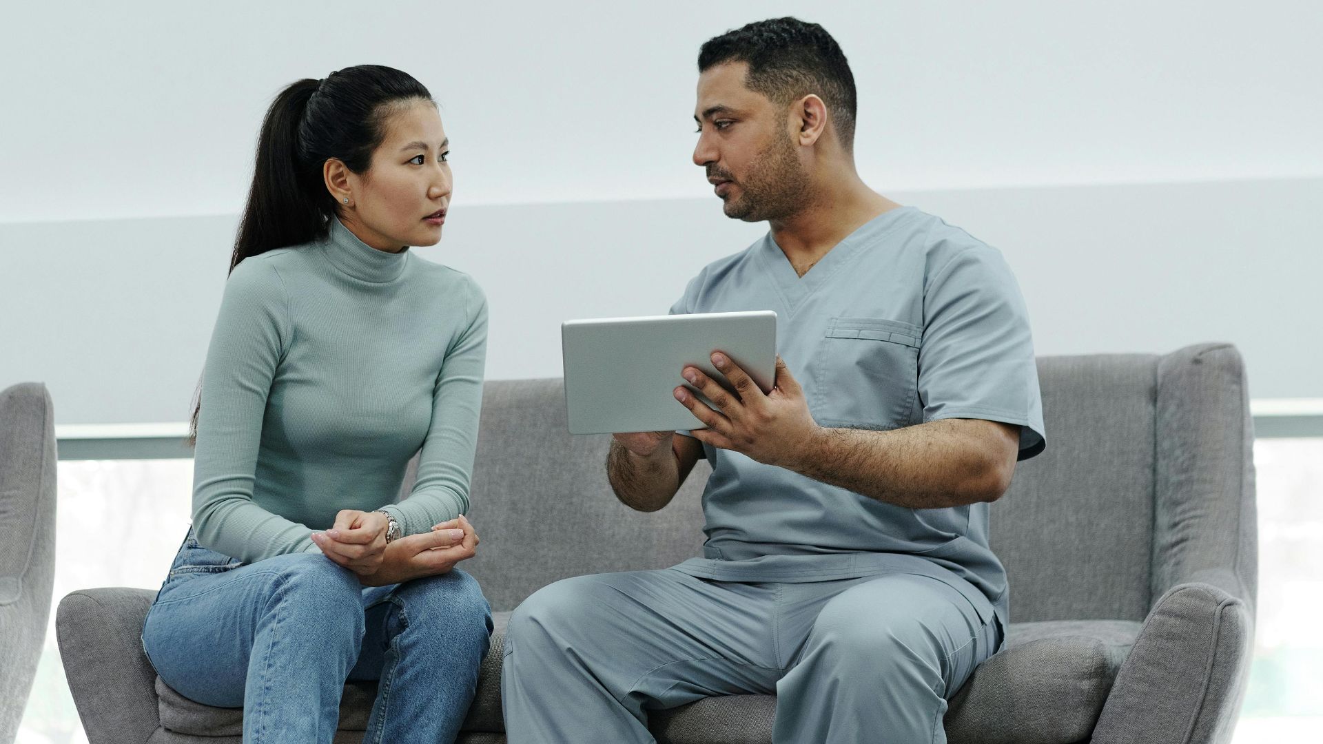 Healthcare provider consulting a patient with a tablet, emphasizing technology in healthcare.