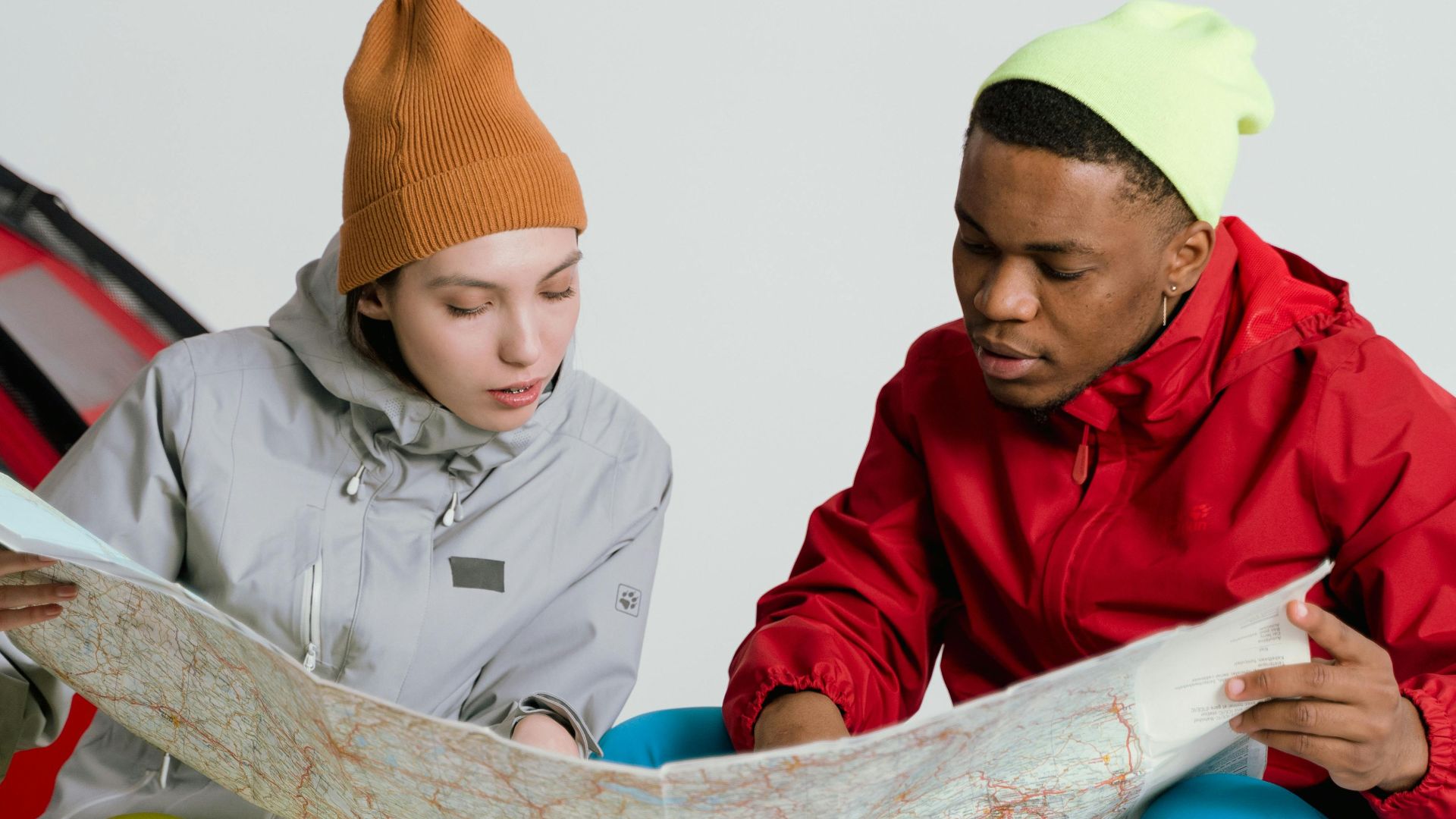 Two young adults studying a map, preparing for a travel adventure together.