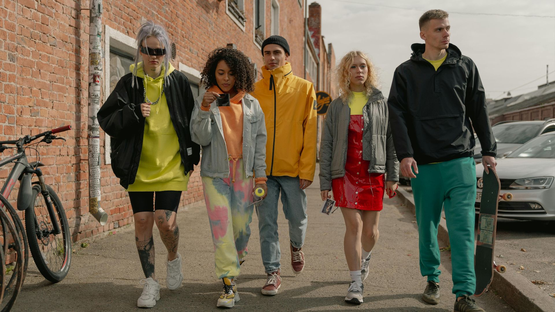 A group of stylish young adults walking together on a city street, showcasing modern fashion.