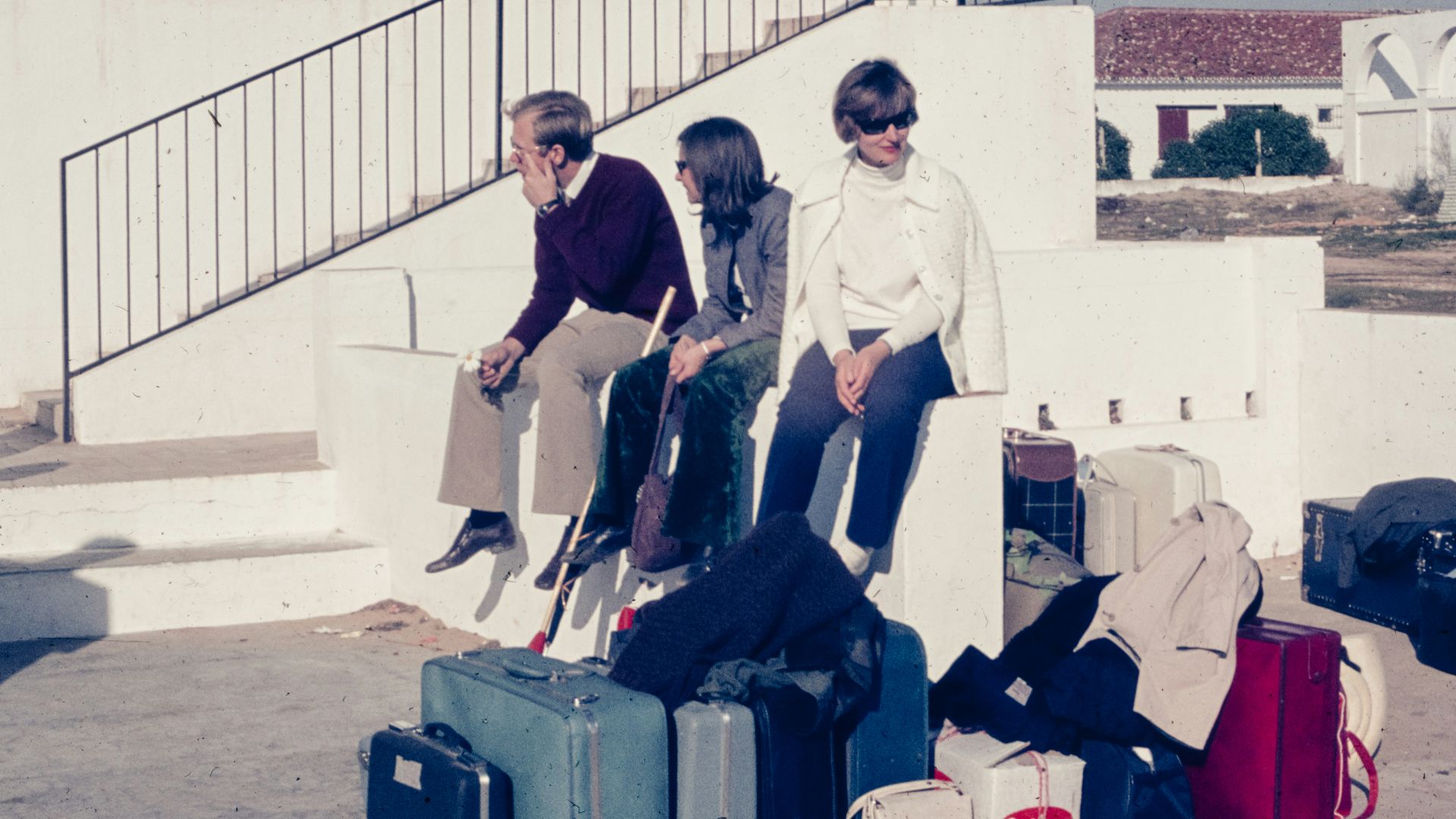 a group of people sitting on top of a pile of luggage