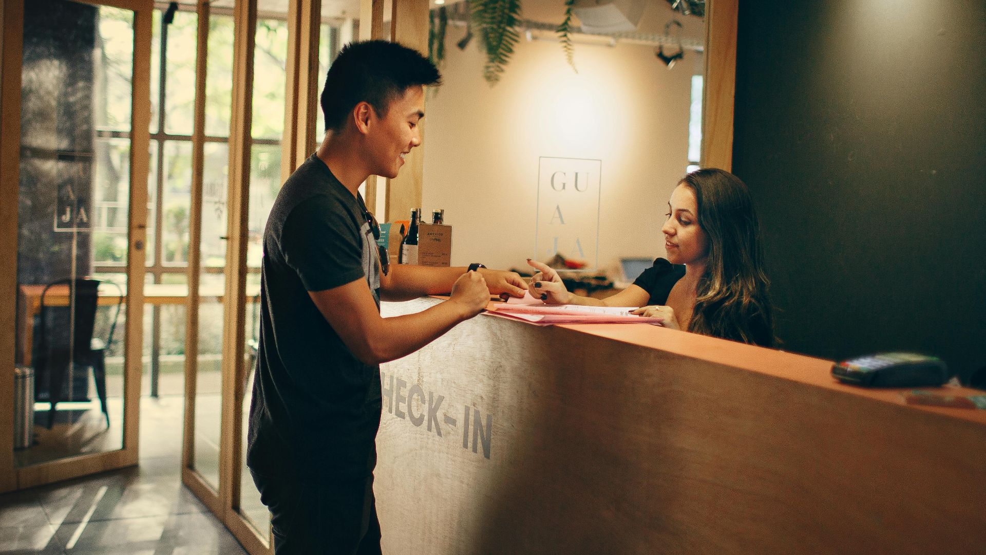 A customer checks in at a hotel reception desk in Belo Horizonte, Brazil.
