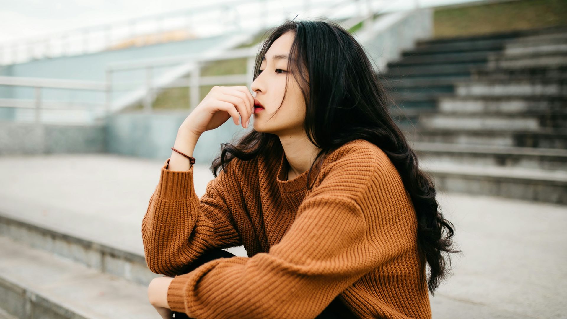 woman wearing brown sweater holding lips