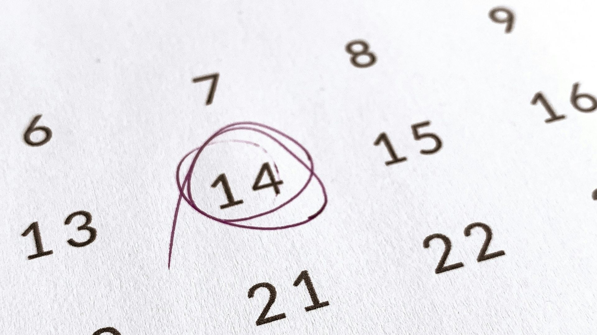a close up of a calendar with a red marker