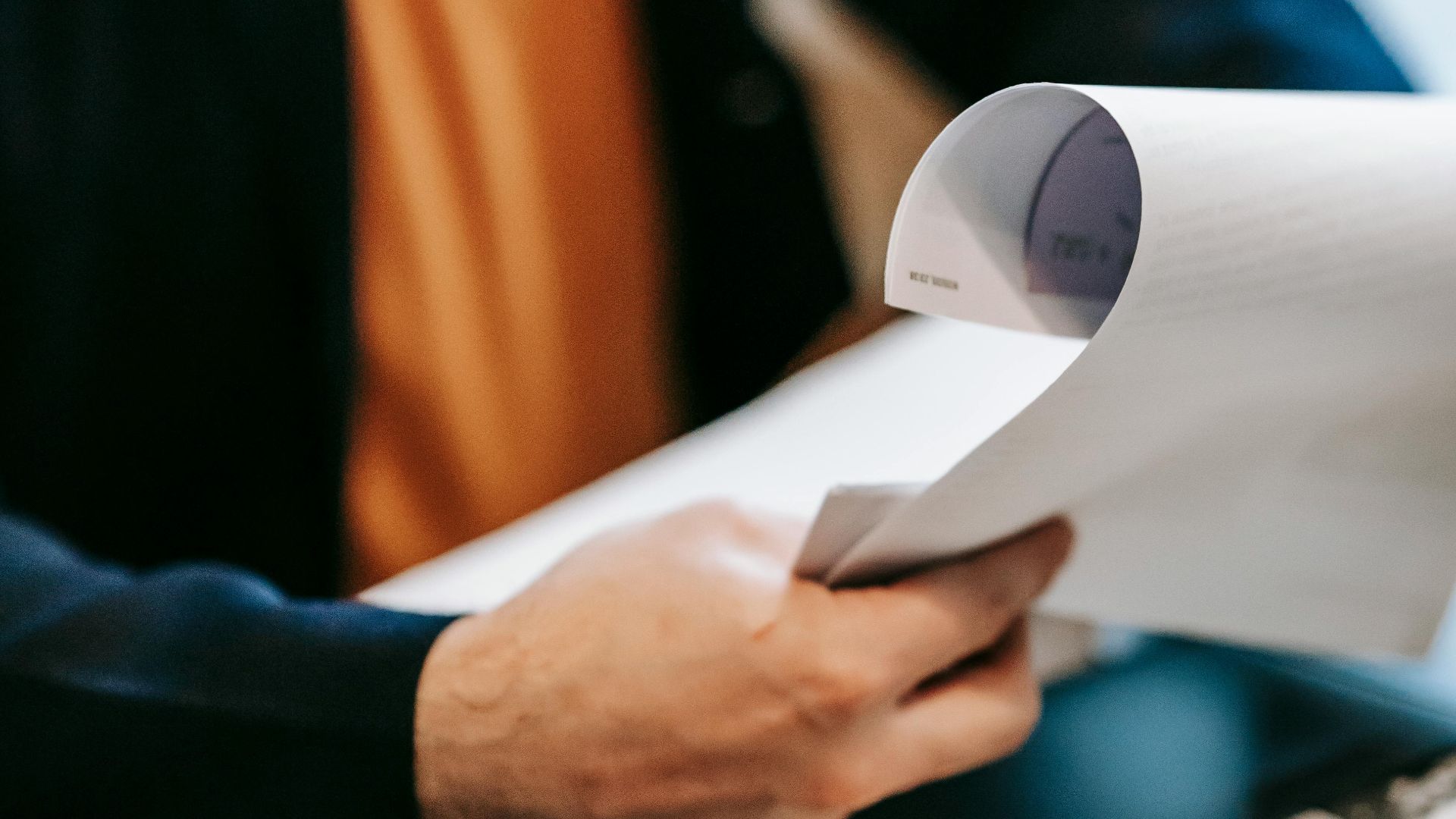Business professional reviewing important documents indoors. Hands focus, blurred background.