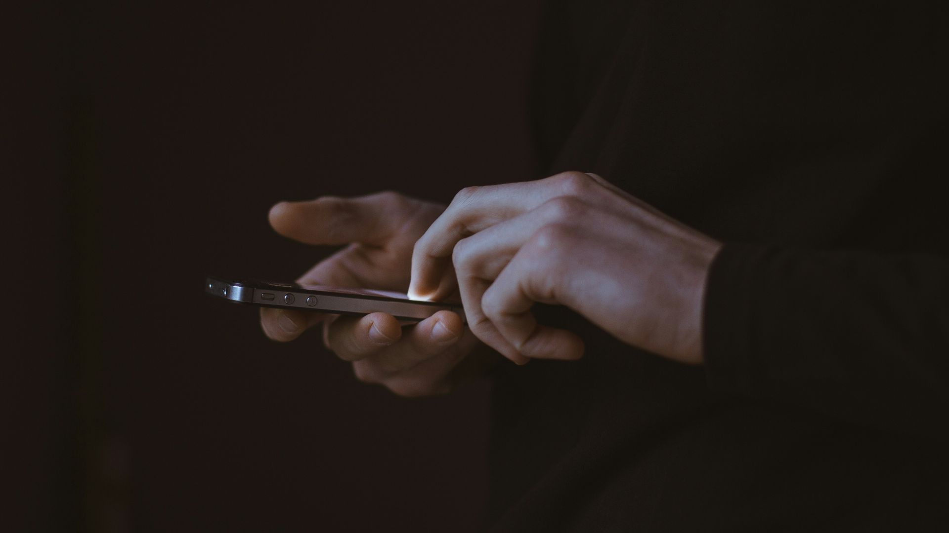 silhouette photo of person holding smartphone