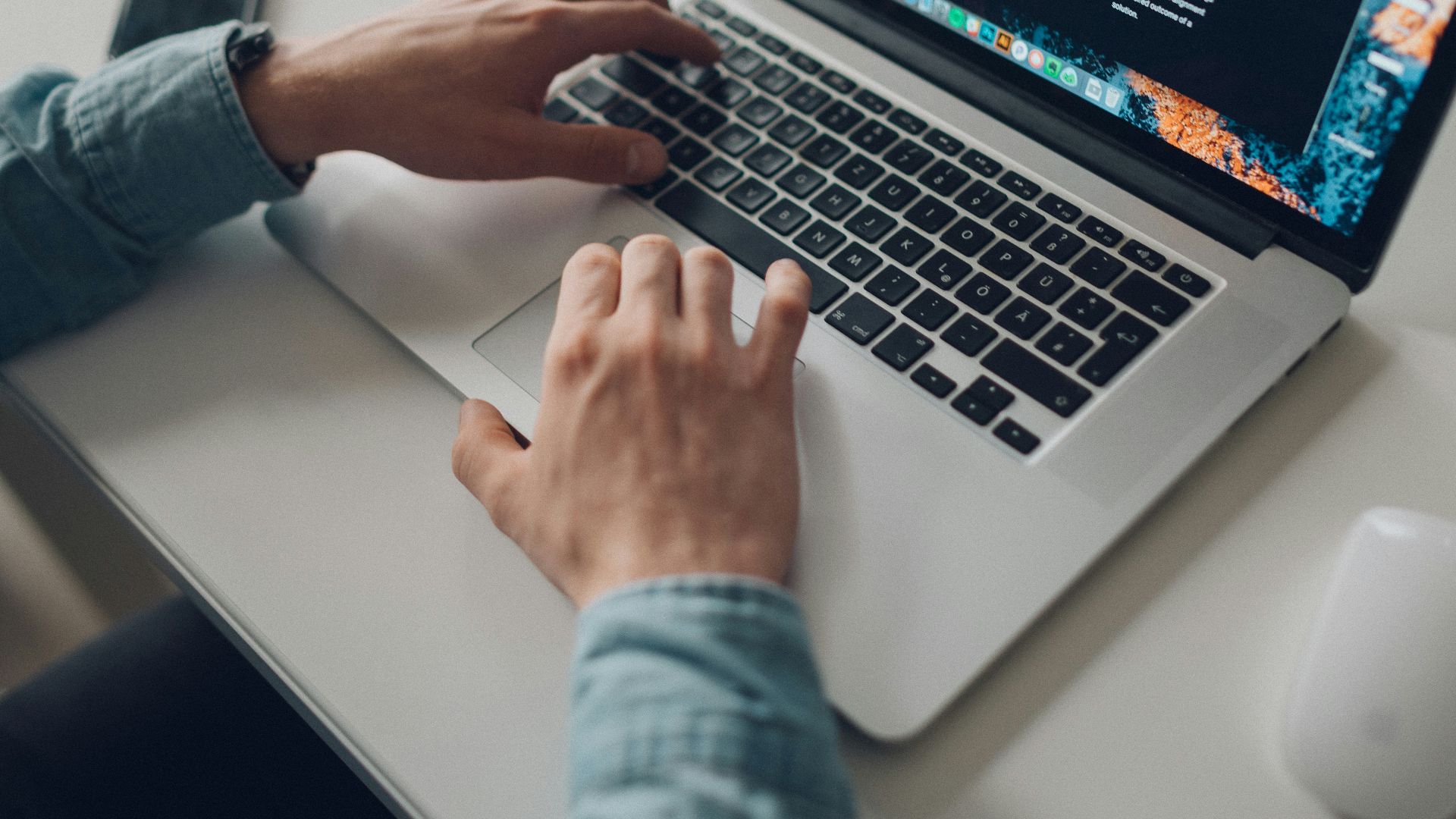 person wearing long-sleeve top working on laptop