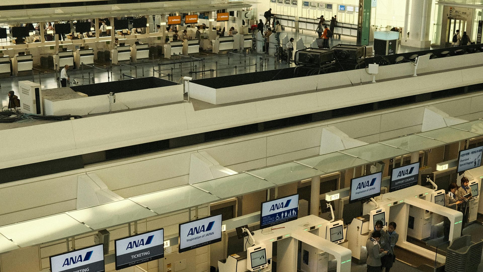 Aerial view of the check-in counters at Haneda Airport, Tokyo, showcasing modern architecture.