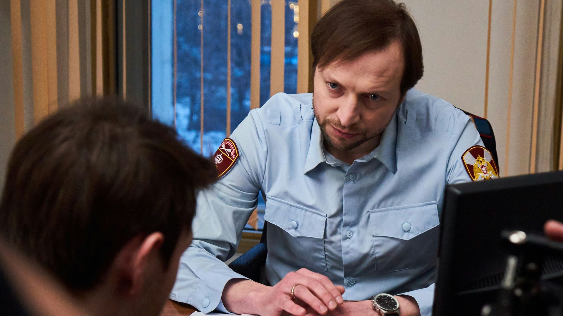 man in blue button up shirt sitting beside woman in black shirt