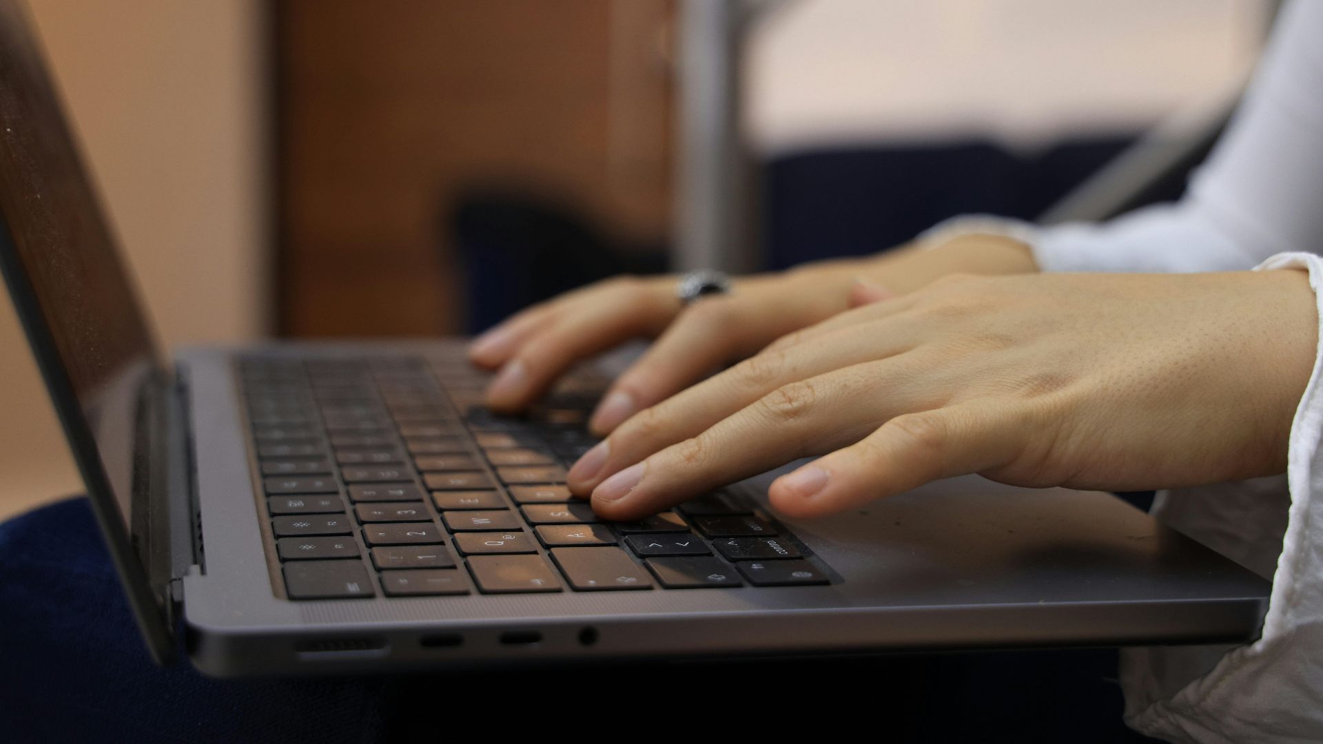 Hands typing on a laptop keyboard in an indoor setting. Perfect for business and technology themes.