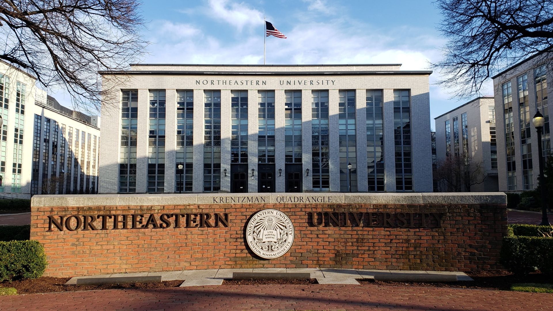 The Northeastern University sign at Krentzman Quad, viewed from Huntington Ave with Ell Hall in the background, often viewed as the center of campus