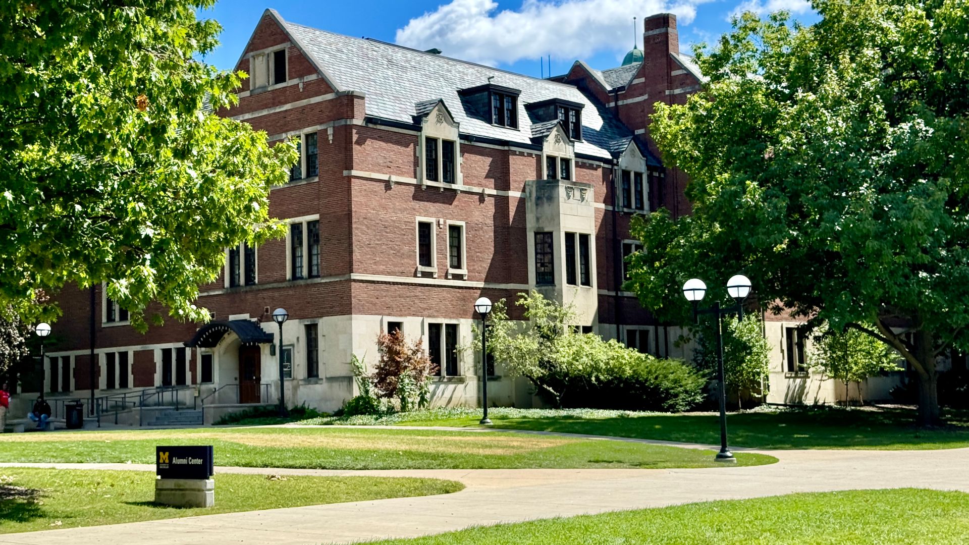 Built in 1927-1929, this Collegiate Gothic Revival-style building was designed by Pond and Pond for the Women’s League of Michigan, now known as the Michigan League, to serve as a student center at the University of Michigan.  The building is clad in red brick with a gabled roof, limestone trim, double-hung windows, multi-story bay windows, brick buttresses, a rectilinear tower at the main entrance, and a copper cupola.  The building is a contributing structure in the University of Michigan Central Campus Historic District, listed on the National Register of Historic Places in 1978.