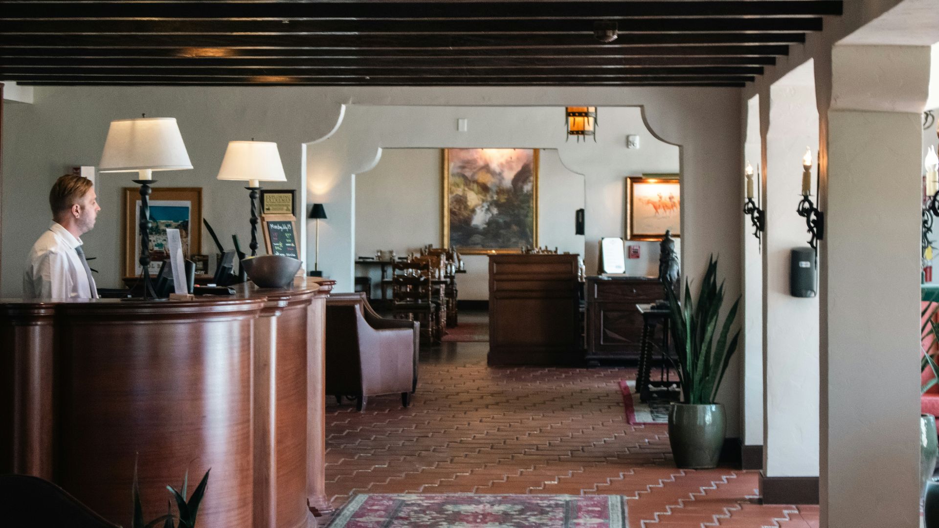 A woman is standing at the front desk of a restaurant