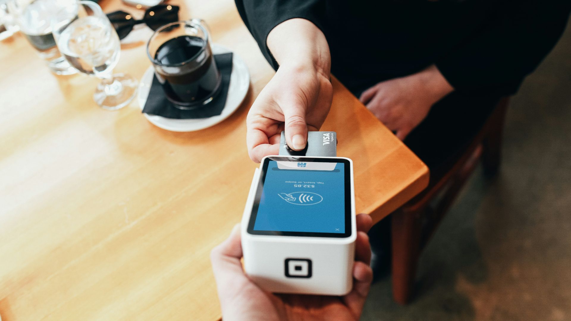 person holding credit card swipe machine
