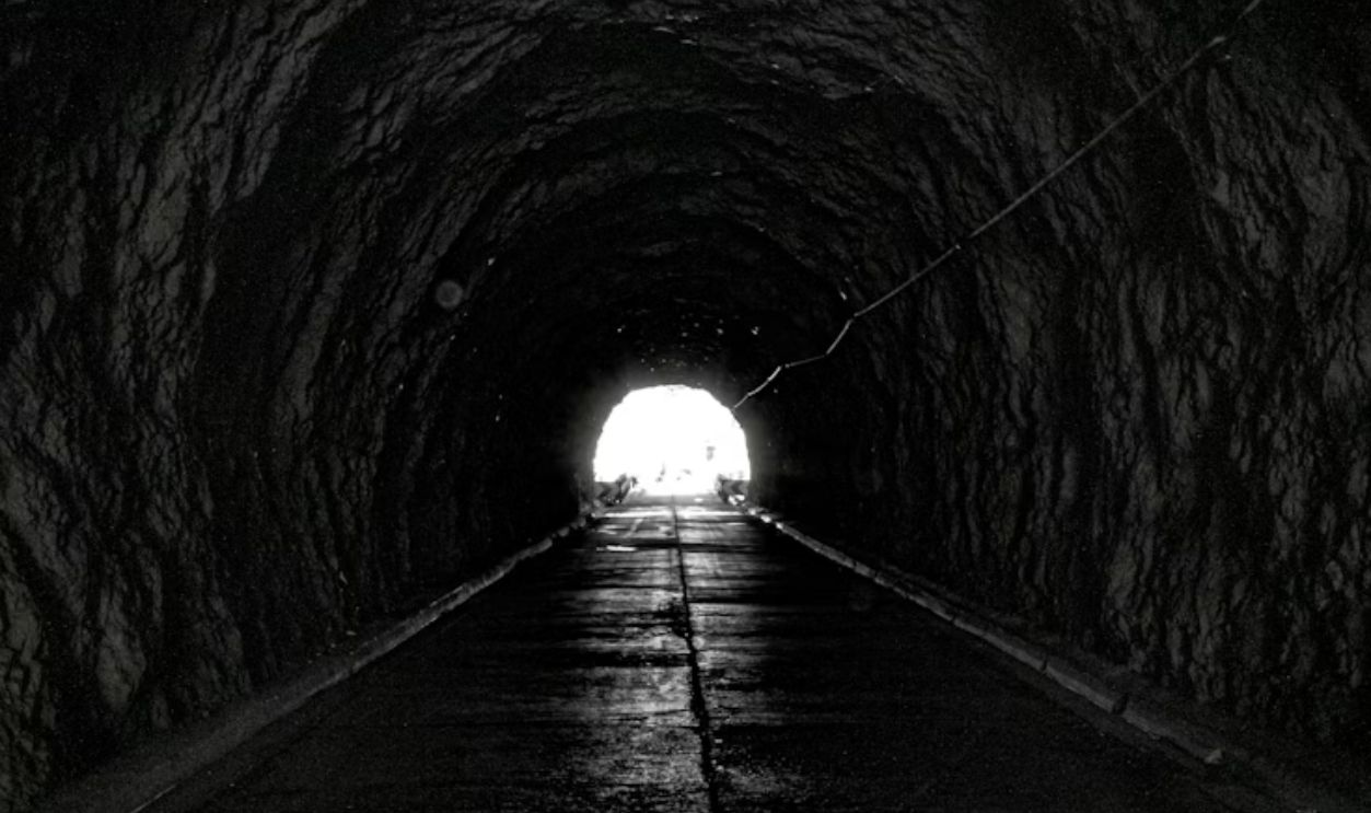 Dark tunnel with bright light at the end