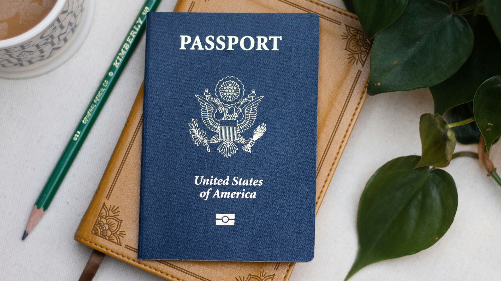 a passport sitting on top of a table next to a cup of coffee