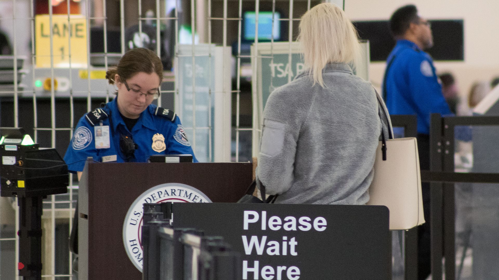 A Transportation Security Administration agent at a checkpoint verifying passenger identification, John Glenn Columbus International Airport