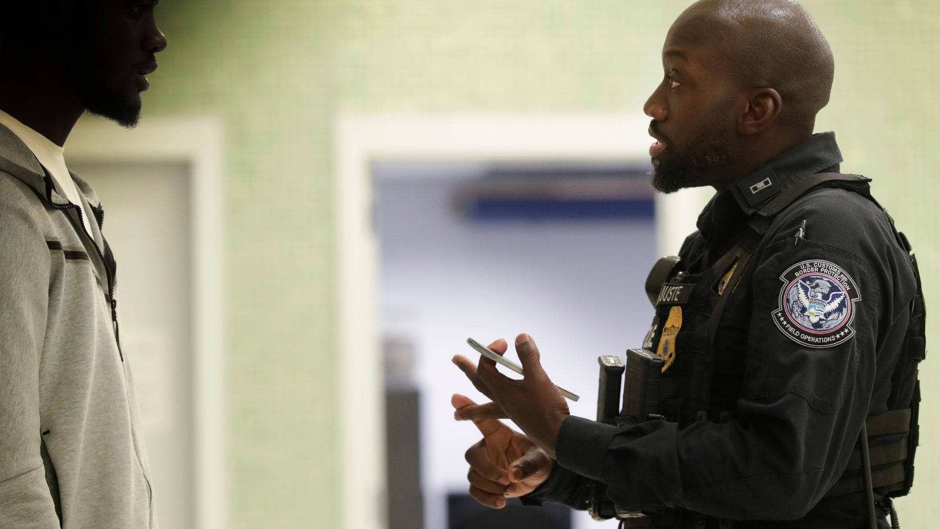A U.S. Customs and Border Protection officer calms an arriving international passenger who has been flagged for questioning at Philadelphia International Airport in Philadelphia, Pa., July 29, 2024. CBP Photo by Glenn Fawcett