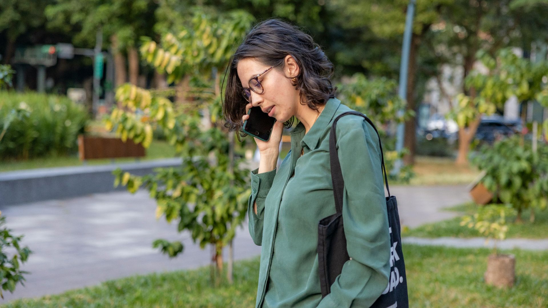 a woman talking on a cell phone in a park