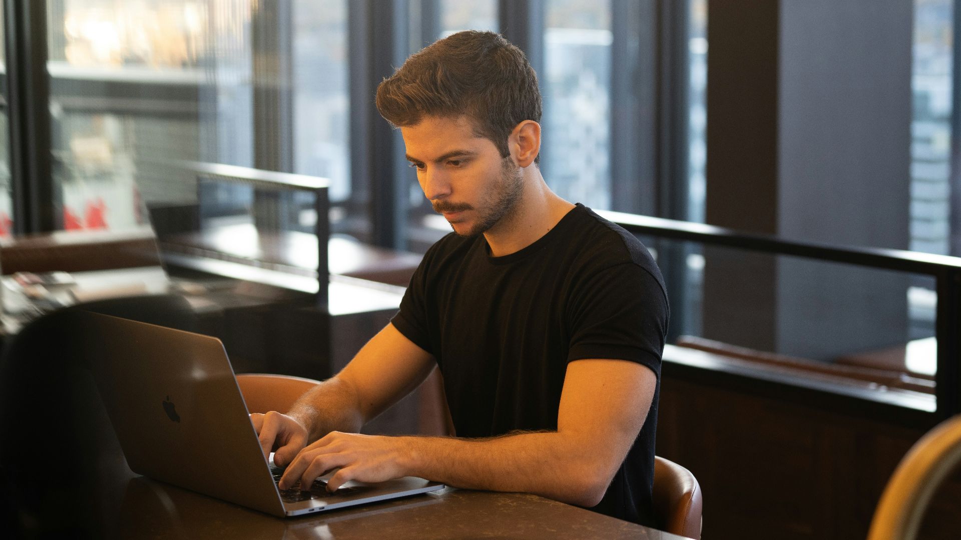 man in black crew neck t-shirt using macbook
