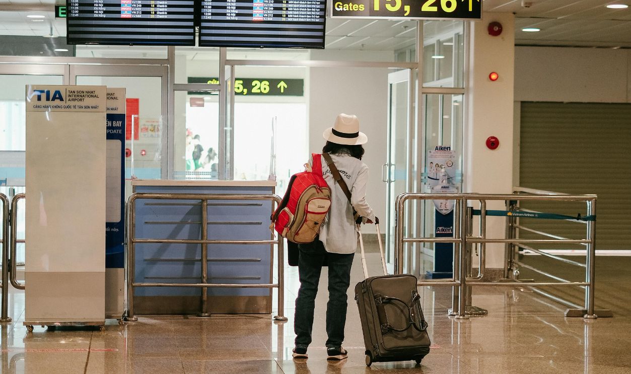 Woman with luggage exploring airport terminal. Solo travel and future adventures.