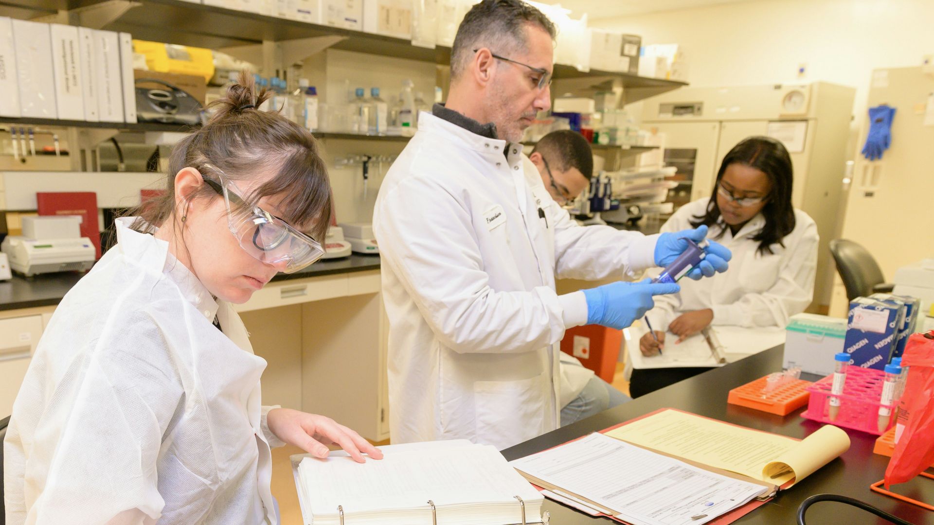 a group of people in lab coats working in a lab