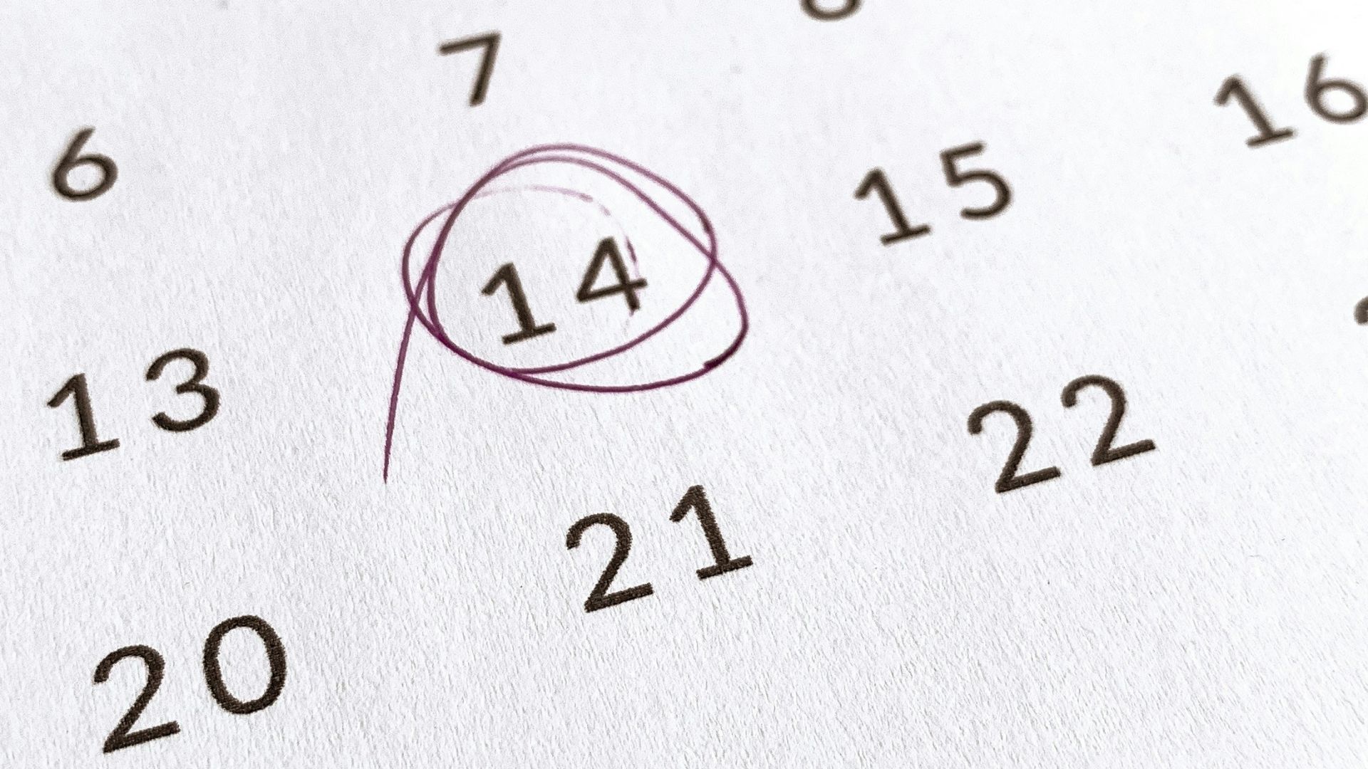 a close up of a calendar with a red marker