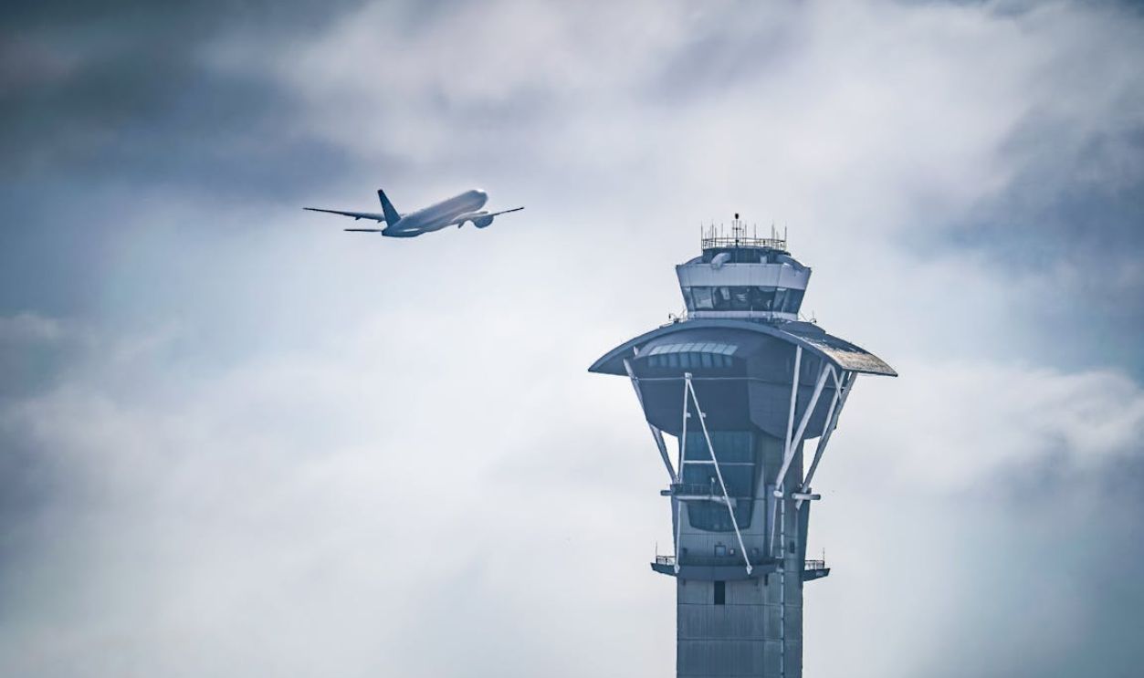 Dramatic shot of an airplane taking off near the iconic LAX control tower in Los Angeles, California.