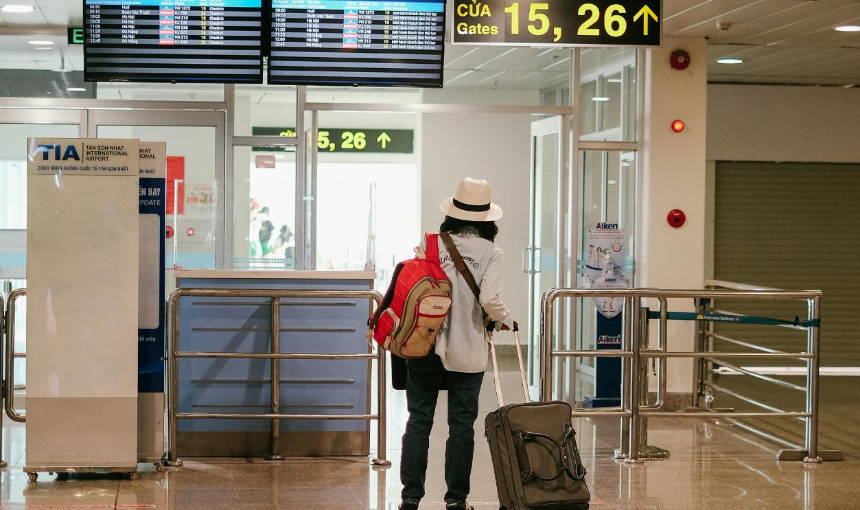 Woman with luggage exploring airport terminal. Solo travel and future adventures