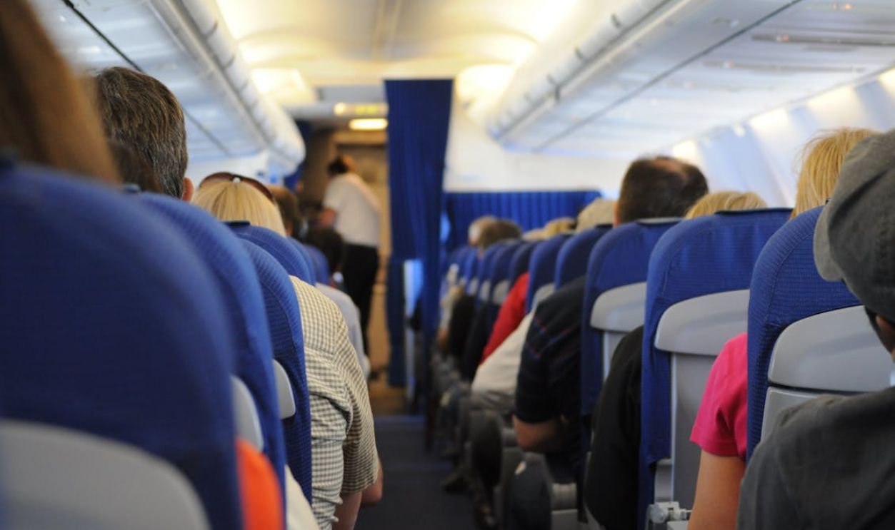 Interior view of an airplane cabin with passengers seated, showcasing air travel experience