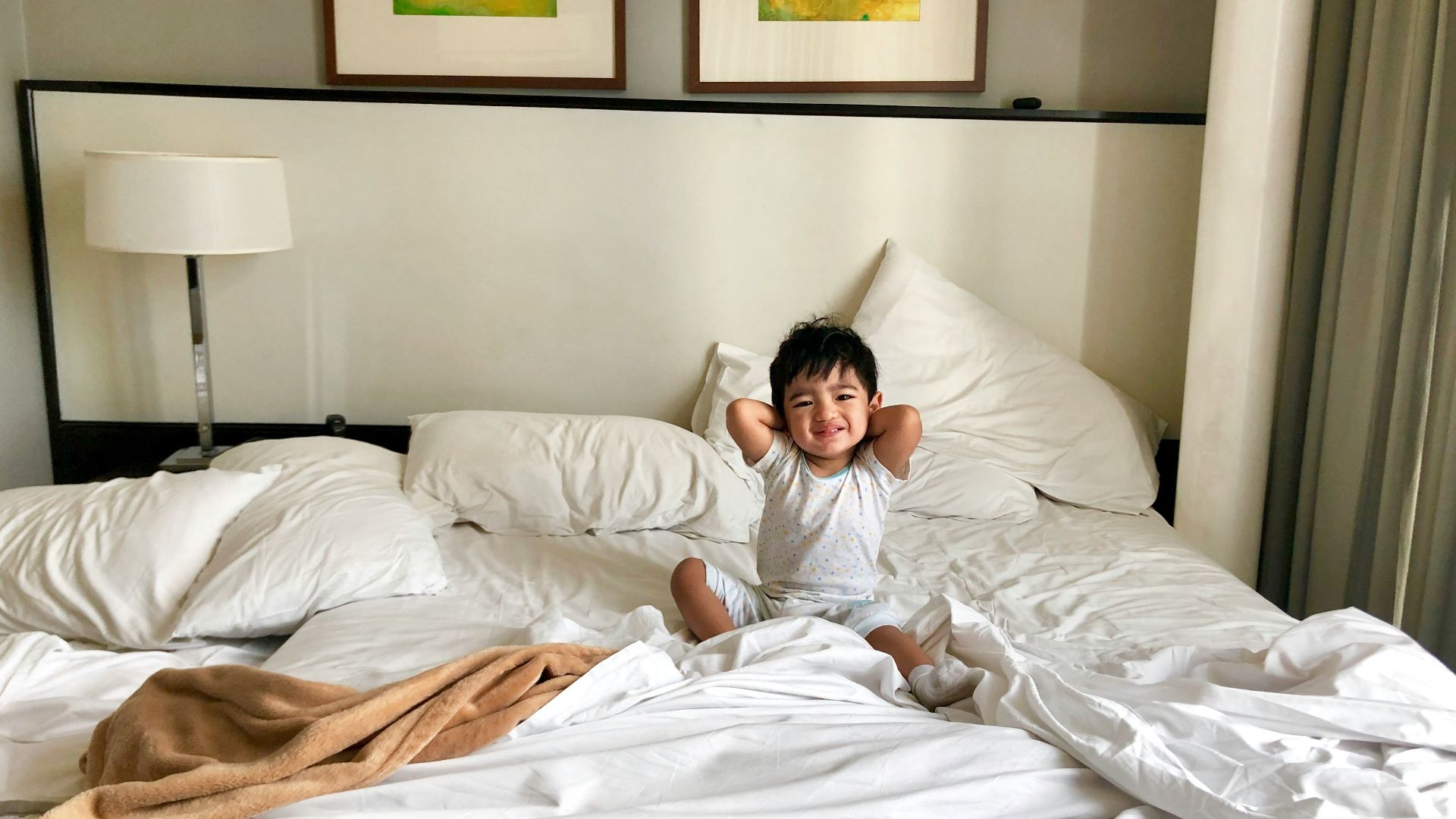 woman in white long sleeve shirt lying on bed
