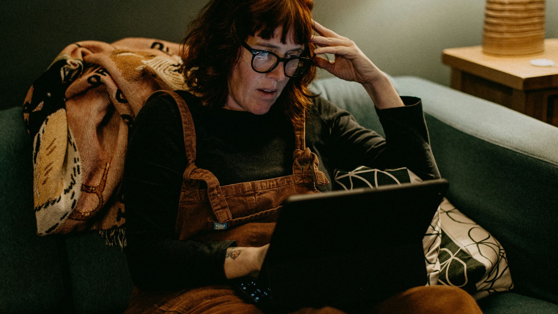 a woman sitting on a couch using a laptop computer